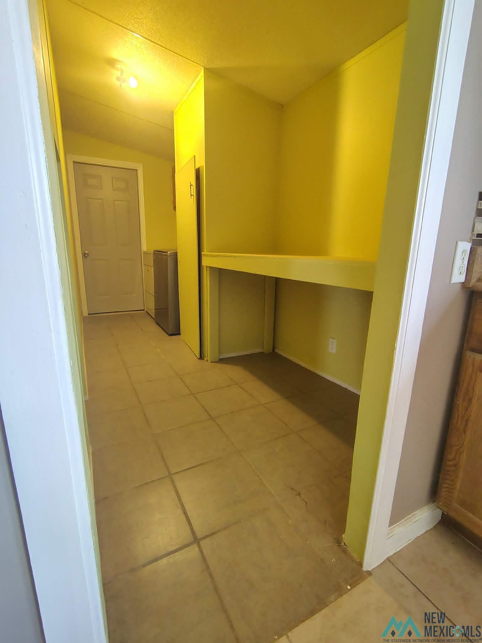 58 Fisk Road Dexter, NM 88230 - Photo 44 of 46 Built-in shelving unit with an integrated desktop, tile flooring, and a flush-mounted ceiling light fixture