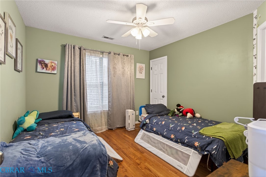 116 Old Field Road Williamsburg, VA 23188 - Photo 22 of 27 Bedroom featuring wood finished floors, a textured ceiling, and ceiling fan