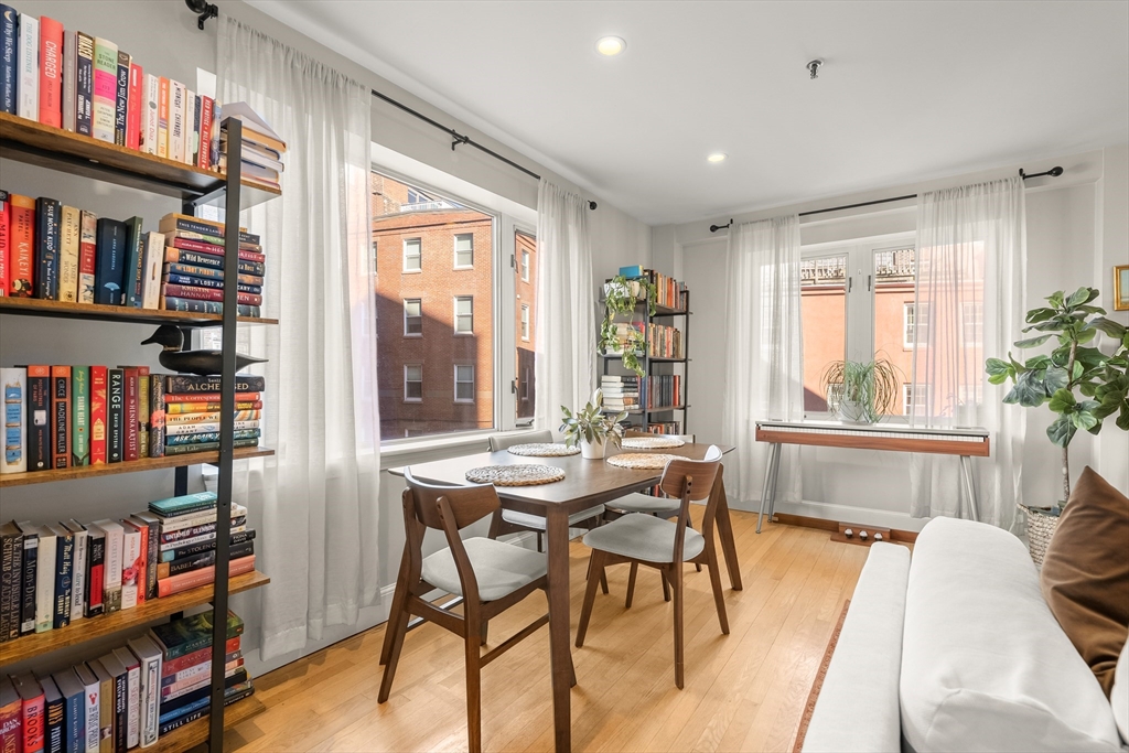 350 North Street, Unit 200 Boston, MA 02113 - Photo 6 of 22 a dining room with furniture a book shelves and wooden floor