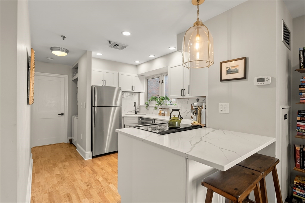 350 North Street, Unit 200 Boston, MA 02113 - Photo 7 of 22 a kitchen with stainless steel appliances granite countertop a sink refrigerator and cabinets
