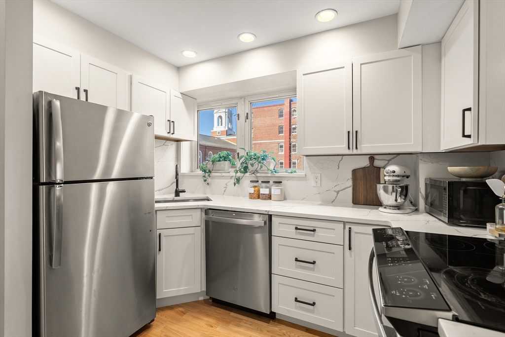 350 North Street, Unit 200 Boston, MA 02113 - Photo 8 of 22 a kitchen with stainless steel appliances granite countertop a refrigerator sink and cabinets