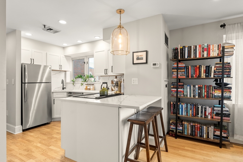 350 North Street, Unit 200 Boston, MA 02113 - Photo 10 of 22 a kitchen with stainless steel appliances granite countertop a refrigerator a stove and a bookshelf