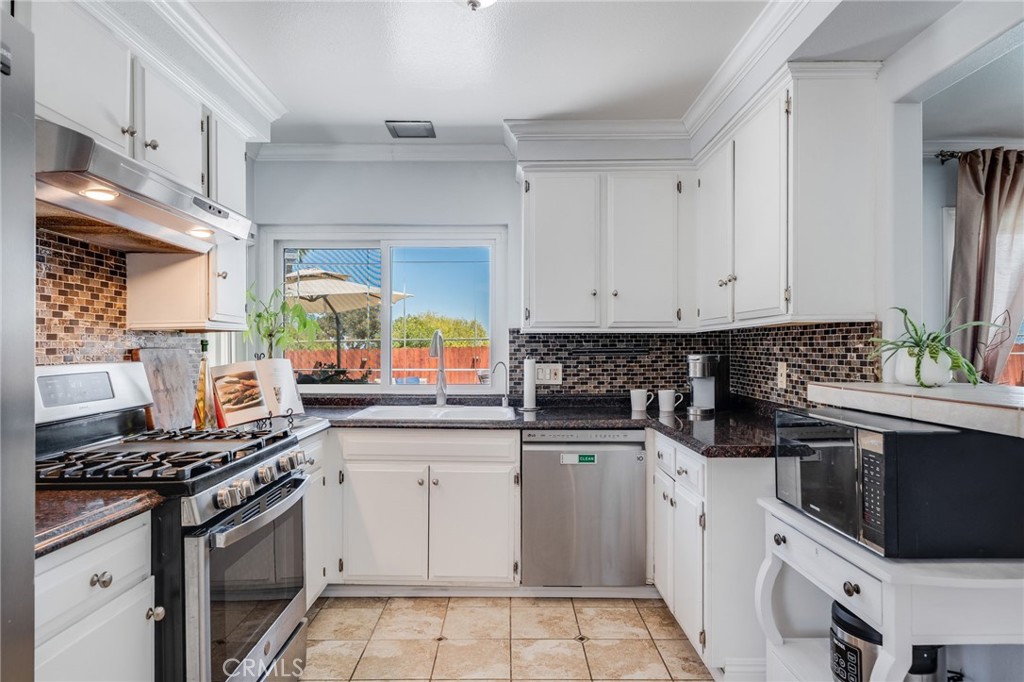 1935 Adobe Avenue Corona, CA 92882 - Photo 15 of 45 a kitchen with white cabinets and appliances