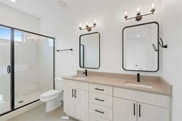 a bathroom with 2 sink toilet and shower