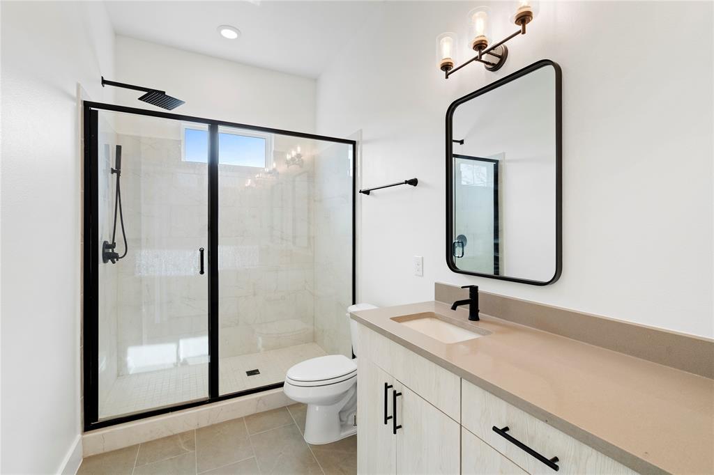1804 Ripley Street, Unit 105 Dallas, TX 75204 - Photo 13 of 25 a bathroom with a shower sink mirror and toilet