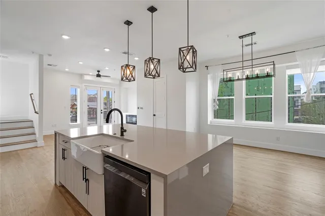 a kitchen with kitchen island a sink a stove and wooden floor