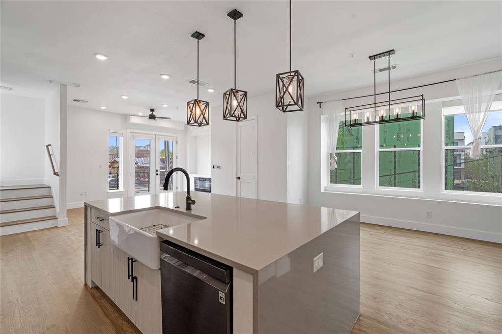 1804 Ripley Street, Unit 105 Dallas, TX 75204 - Photo 5 of 25 a kitchen with kitchen island a sink a stove and wooden floor