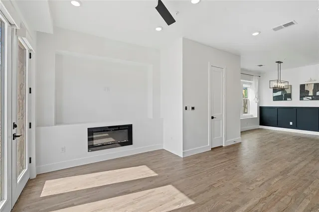 a living room with stainless steel appliances wooden floor and rug