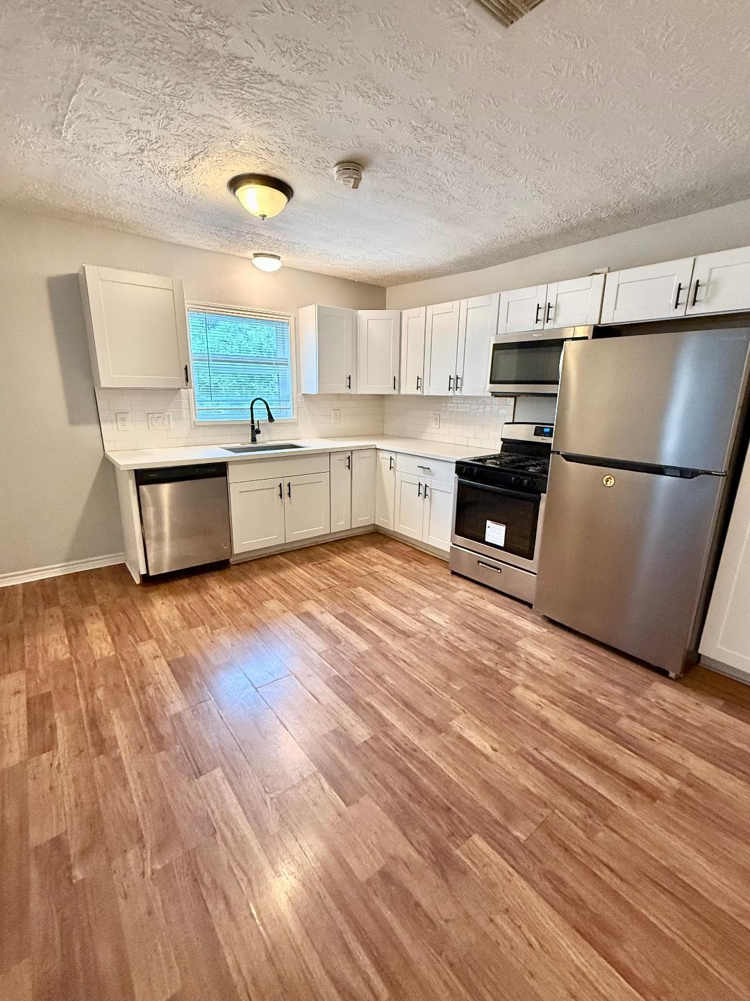 306 Rustic Drive Pasadena, TX 77502 - Photo 7 of 28 a kitchen with stainless steel appliances granite countertop a refrigerator a stove and a wooden floors