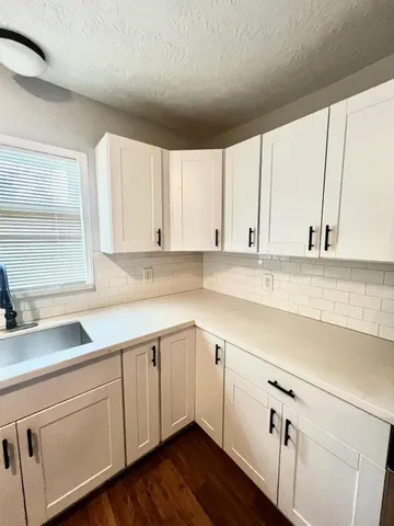 a kitchen with a sink cabinets and window