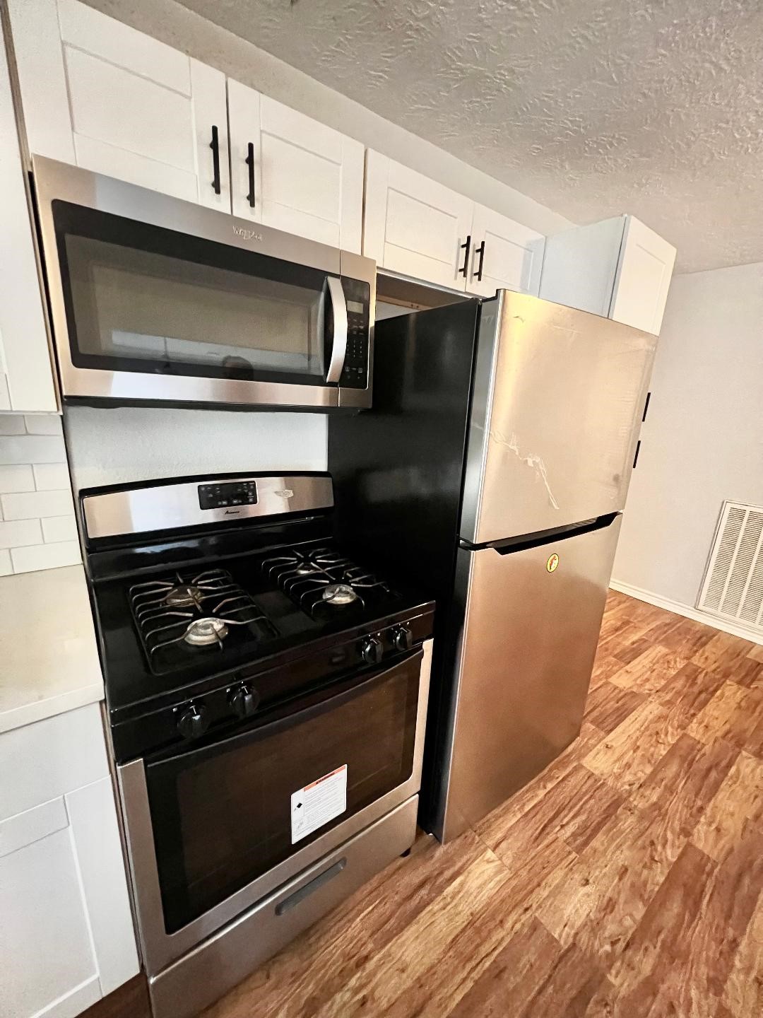 306 Rustic Drive Pasadena, TX 77502 - Photo 10 of 28 a kitchen with granite countertop a stove and a microwave