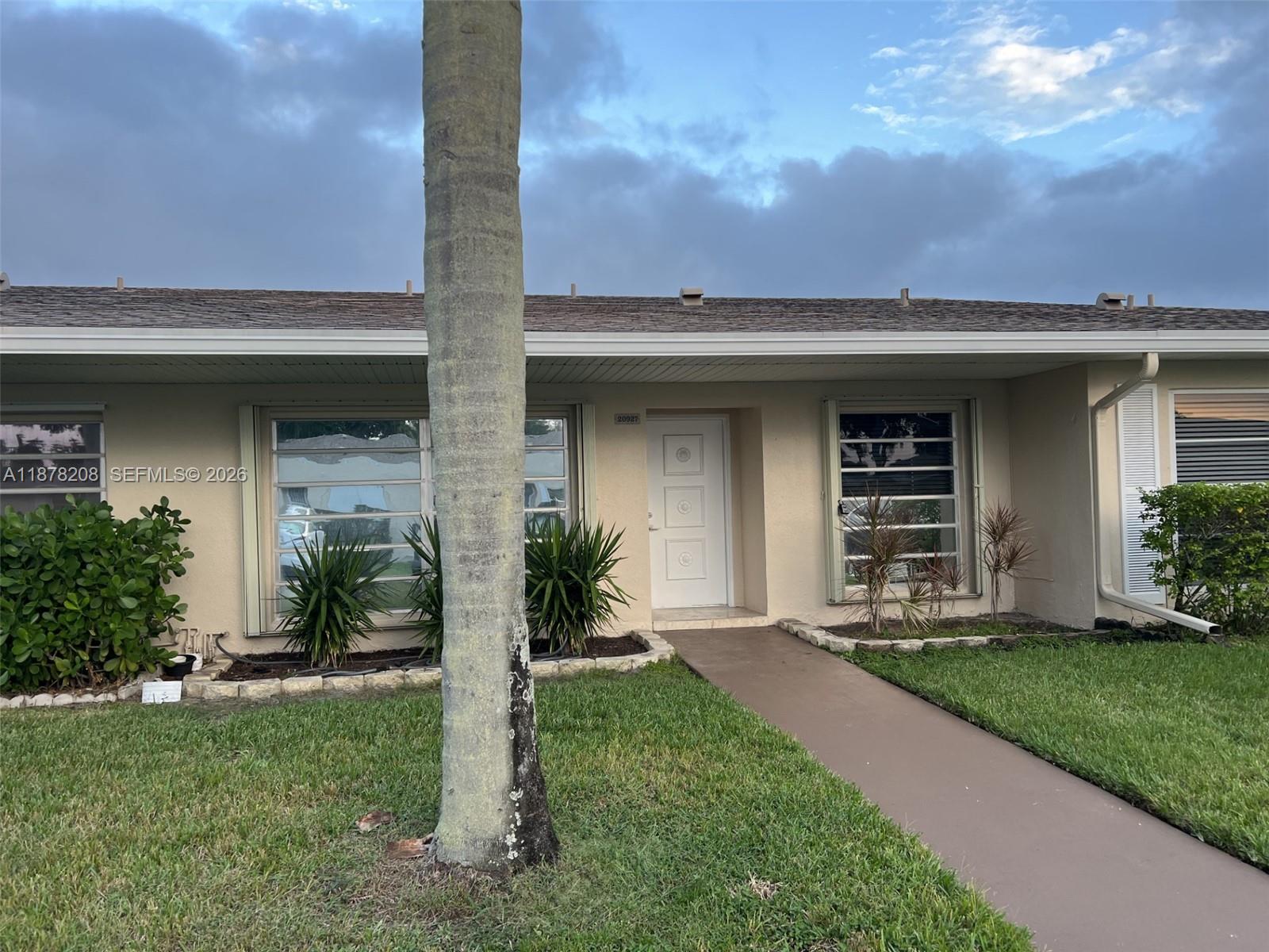 20927 Sedgewick Drive, Unit 20927 Boca Raton, FL 33433 - Photo 2 of 23 a front view of a house with a yard and garage