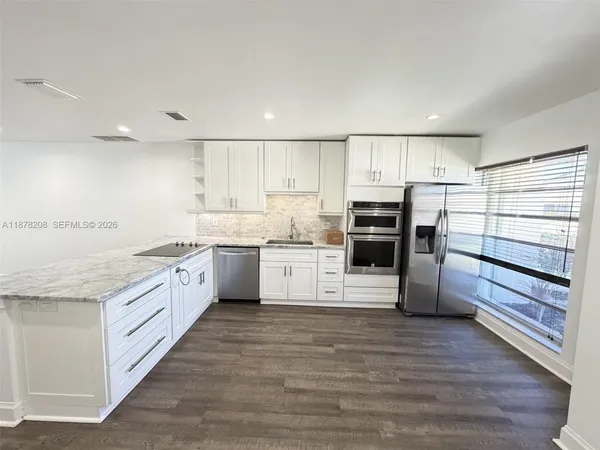 a kitchen with stainless steel appliances granite countertop a stove and more cabinets