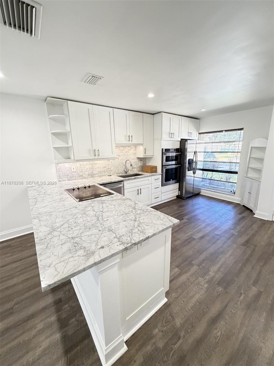 20927 Sedgewick Drive, Unit 20927 Boca Raton, FL 33433 - Photo 8 of 23 a kitchen with stainless steel appliances granite countertop a stove a sink and white cabinets