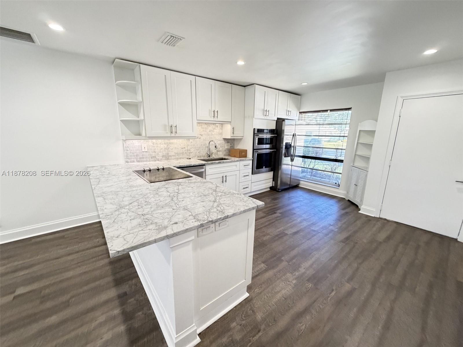 20927 Sedgewick Drive, Unit 20927 Boca Raton, FL 33433 - Photo 9 of 23 a kitchen with stainless steel appliances granite countertop a lot of counter space and wooden floor