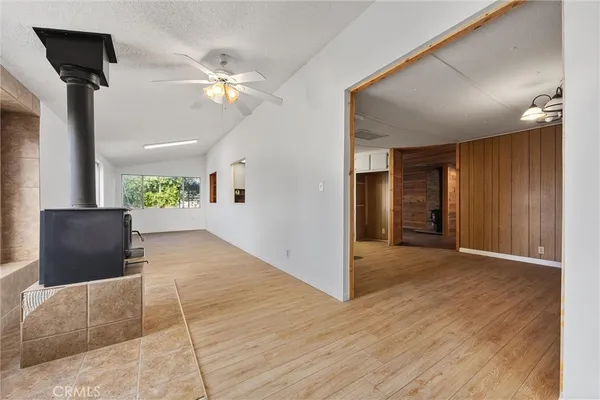 a view of a kitchen with furniture wooden floor ceiling fan and windows