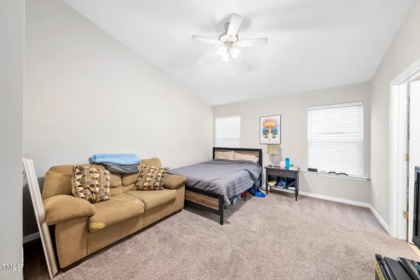 a spacious bedroom with a bed a couch and a window