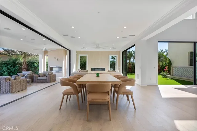 a kitchen with stainless steel appliances granite countertop a stove a sink a refrigerator and a dining table with white cabinets