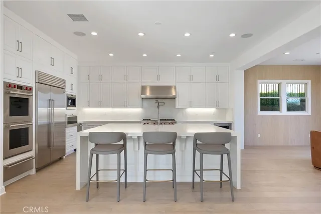 a kitchen with white cabinets and stainless steel appliances