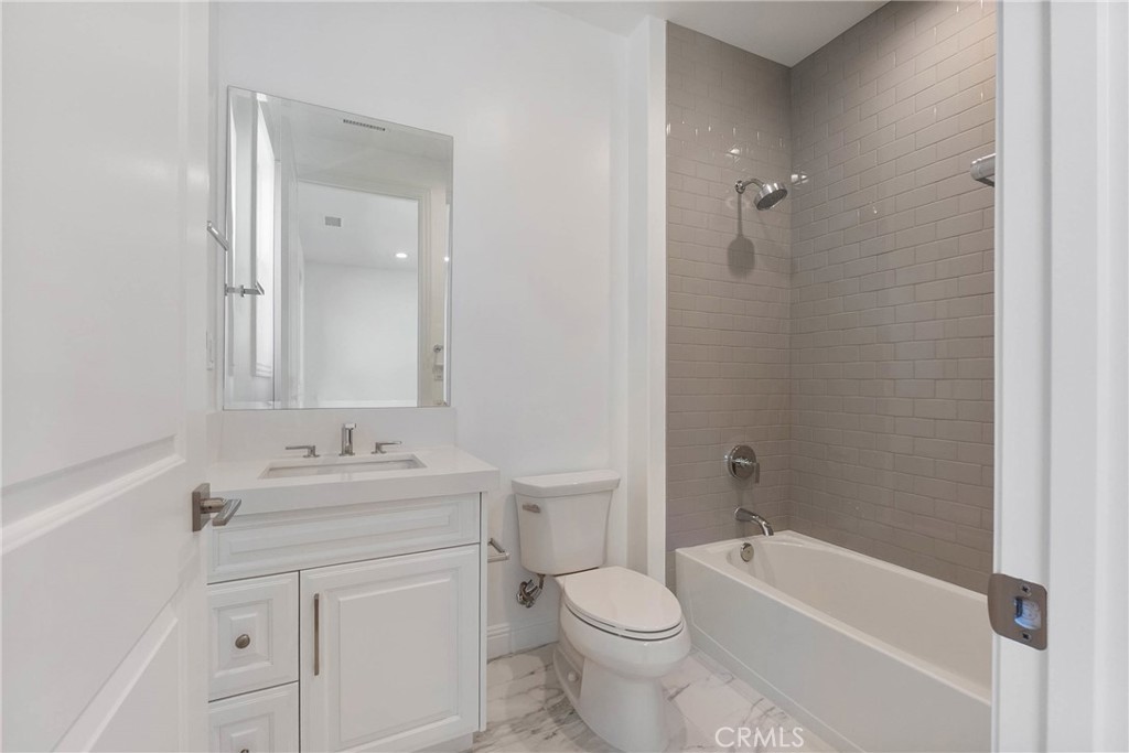 20448 Liverpool Way Porter Ranch, CA 91326 - Photo 35 of 60 a bathroom with a toilet a sink a mirror a bathtub and vanity
