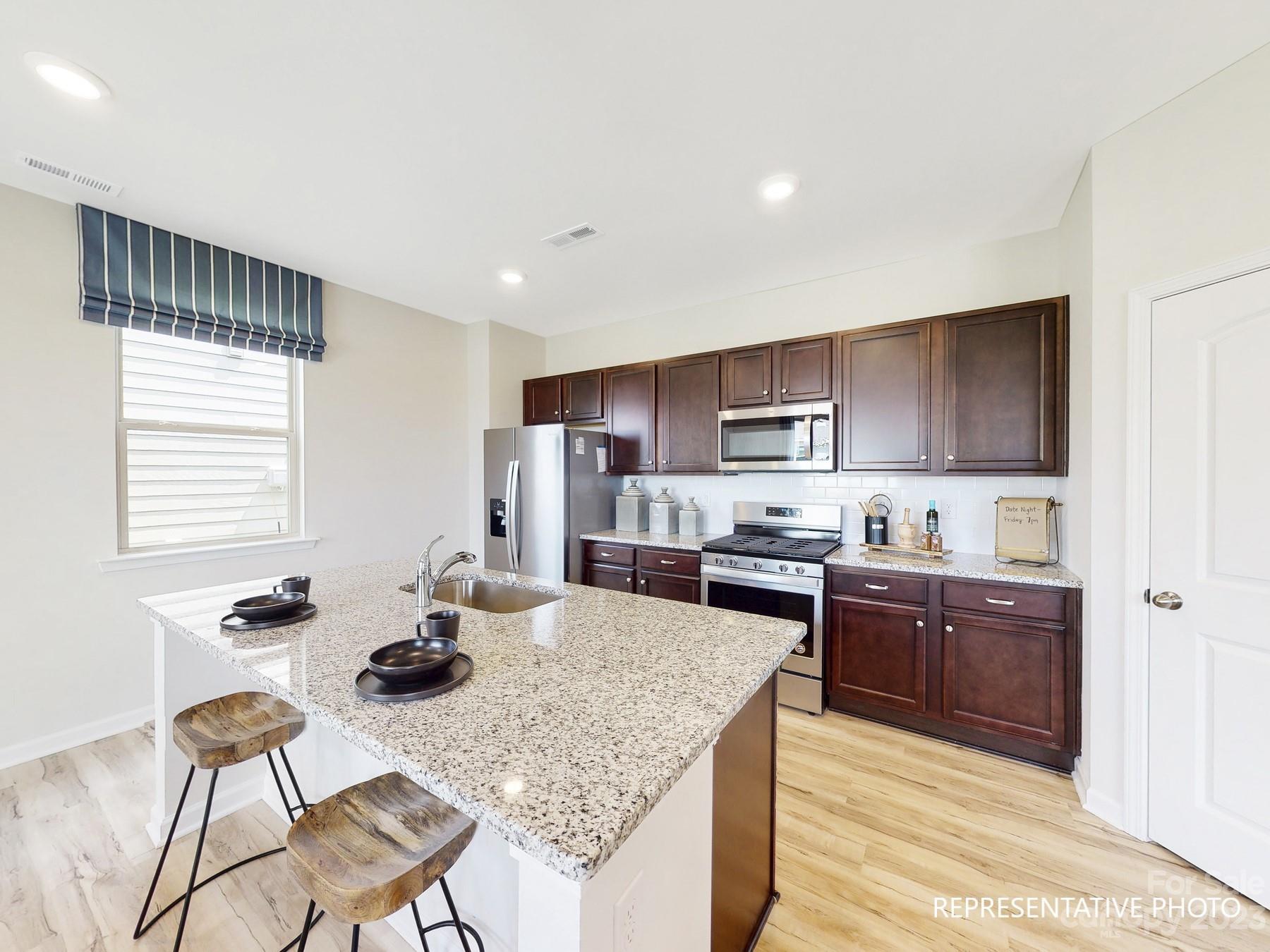4911 Raspberry Knoll Drive, Unit 41 Charlotte, NC 28208 - Photo 11 of 29 a kitchen with stainless steel appliances kitchen island granite countertop a sink and cabinets