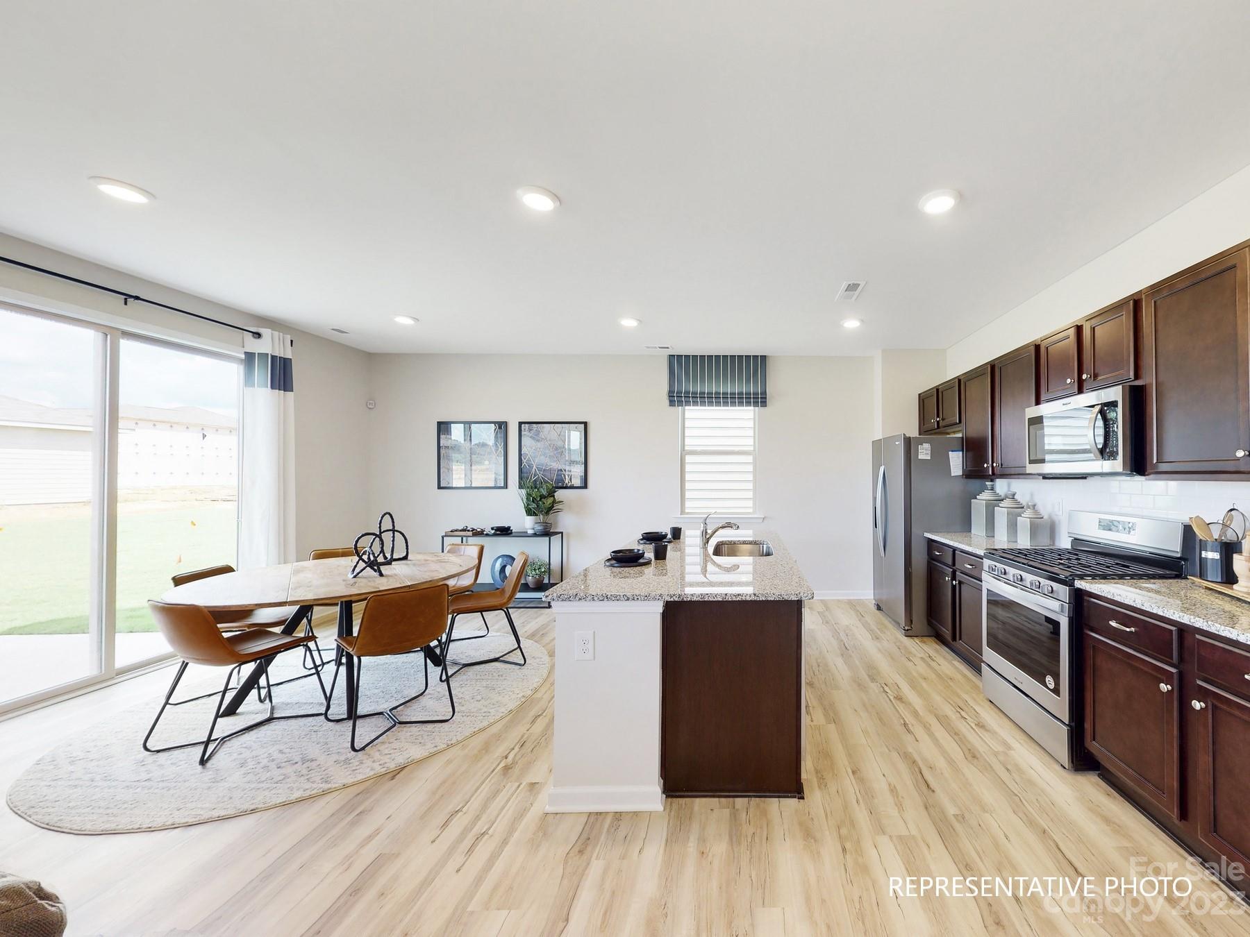 4911 Raspberry Knoll Drive, Unit 41 Charlotte, NC 28208 - Photo 12 of 29 a living room with stainless steel appliances granite countertop furniture wooden floor and a window