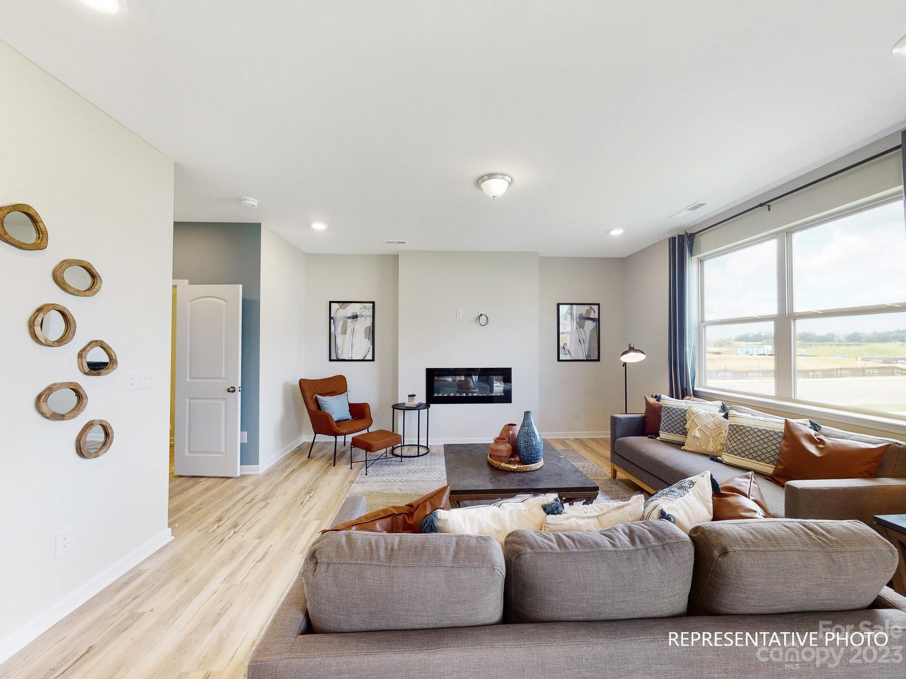 4911 Raspberry Knoll Drive, Unit 41 Charlotte, NC 28208 - Photo 18 of 29 a living room with furniture flat screen tv and a large window