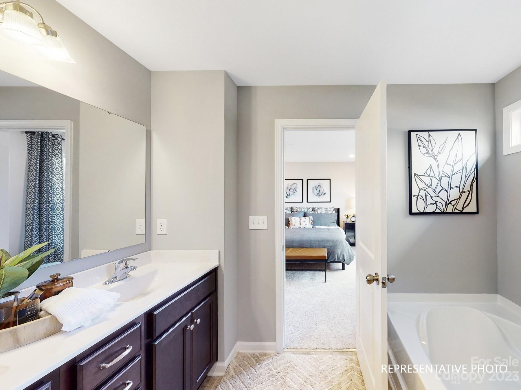 4911 Raspberry Knoll Drive, Unit 41 Charlotte, NC 28208 - Photo 22 of 29 a en suite bathroom with a granite countertop sink and a bathtub