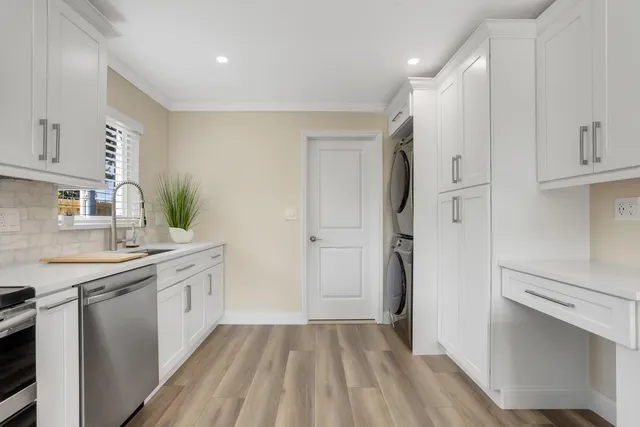 a kitchen with a sink refrigerator and cabinets