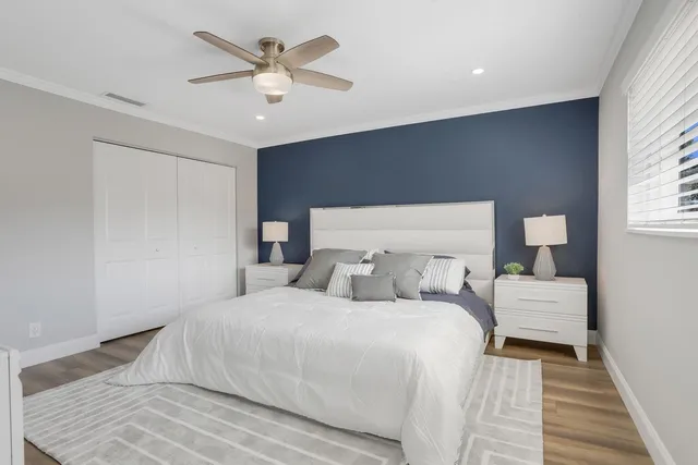 a bedroom with a bed and a ceiling fan