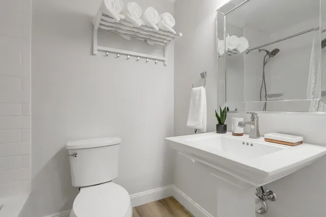 a bathroom with a sink a toilet and shower