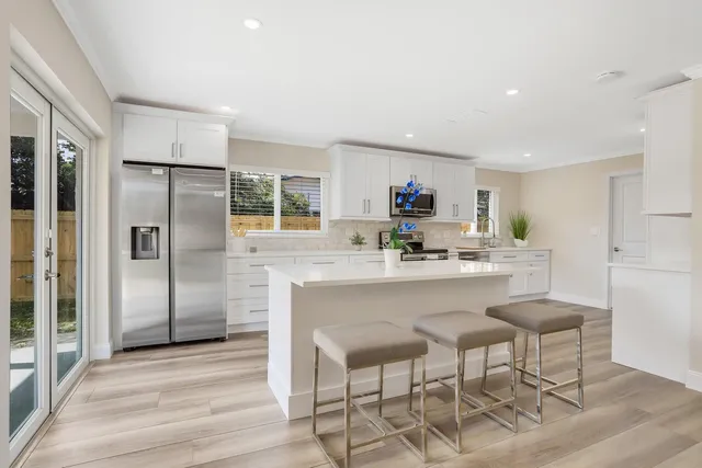 a kitchen with stainless steel appliances a refrigerator and a stove top oven