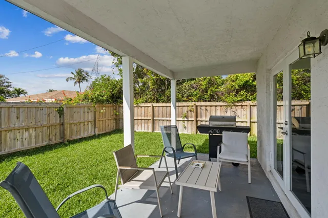a view of a patio with a table chairs and a backyard