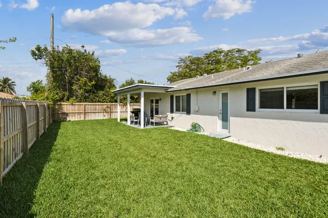a front view of a house with a yard and potted plants