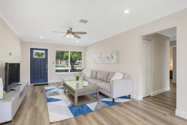 a living room with furniture a flat screen tv and a window