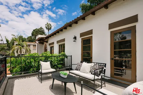 a view of a patio with couches table and chairs and potted plants
