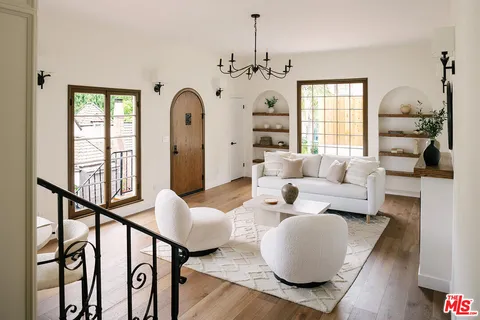 a living room with furniture chandelier and a window
