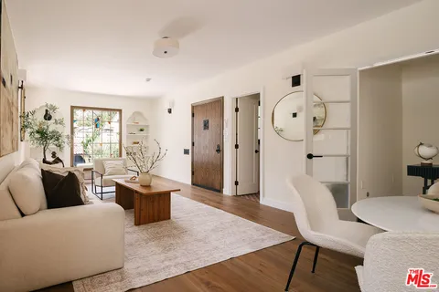 a living room with furniture a wooden floor and a large window