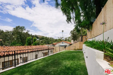 a view of a house with a yard and wooden fence