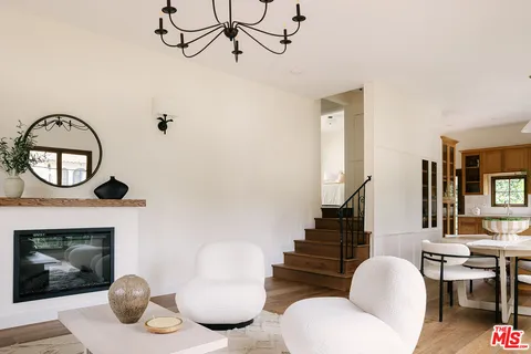 a living room with furniture a fireplace and wall paintings
