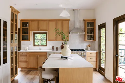 a kitchen with a table chairs refrigerator and cabinets