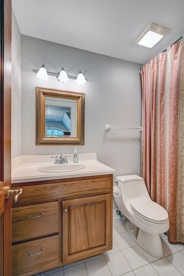 5 Norman Court Burr Ridge, IL 60527 - Photo 35 of 52 a bathroom with a toilet a sink and a mirror
