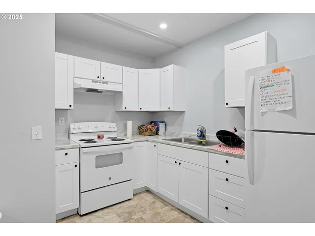 a kitchen with white cabinets and white appliances