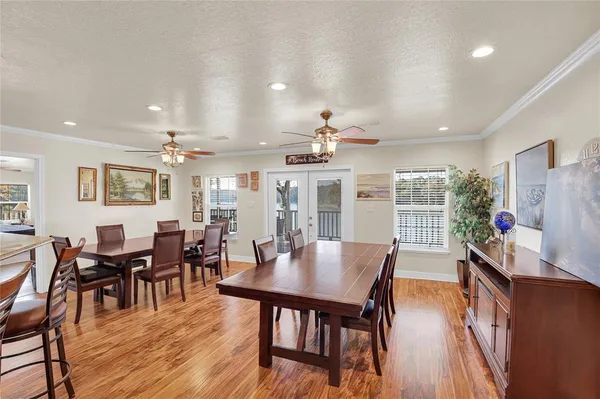 a dining room with wooden floor a chandelier a wooden table and chairs