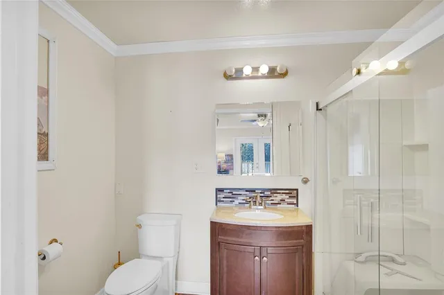 a bathroom with a granite countertop sink a toilet and a mirror