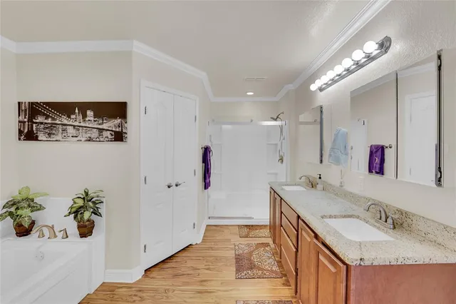 a spacious bathroom with a granite countertop double vanity sink a mirror and shower