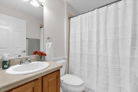 a bathroom with a sink a toilet and shower curtain