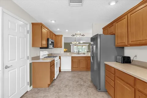 a kitchen with stainless steel appliances granite countertop a refrigerator sink and microwave