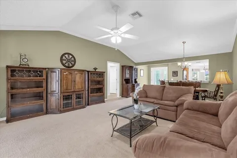 a living room with furniture a clock and a ceiling fan