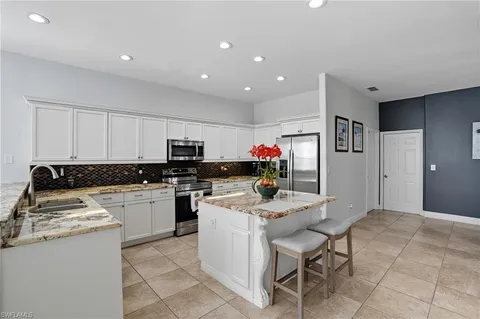 a kitchen with a sink a microwave and cabinets